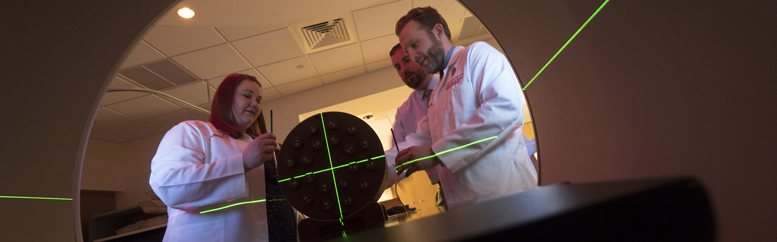 Medical Physics Residents and faculty adjusting LINAC