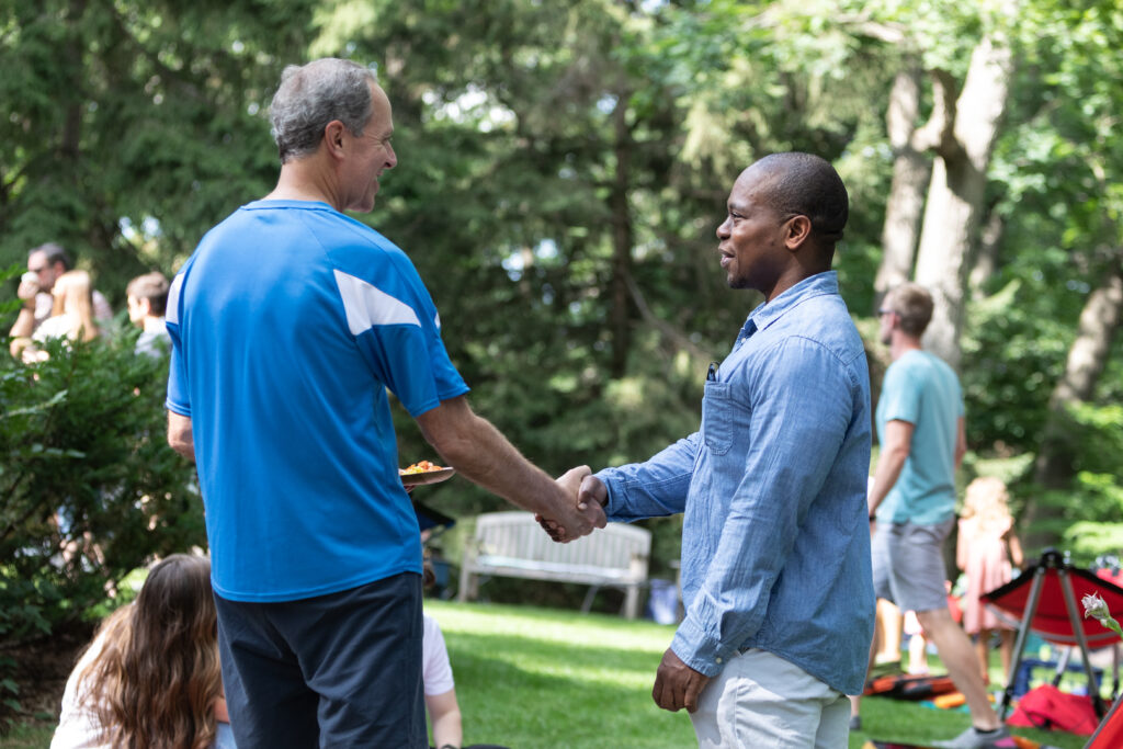 Dr. Harari shakes hands with Dr. Quaovi Sodji at 2022 DHO picnic