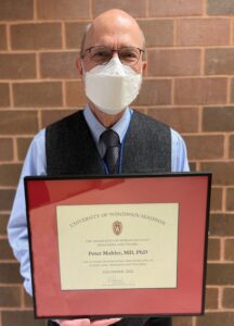 Professor Peter Mahler holding his certificate of appreciation,