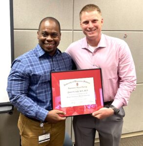 Dr. Quaovi Sodji receiving certificate from Dr. Zach Morris