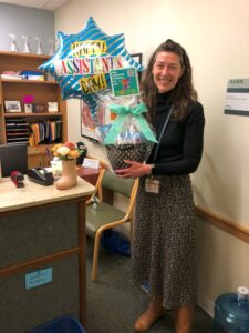 Image of Physics Administrative Assistant, Jami Wood holding baloon and basket of goodies