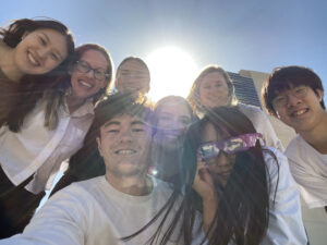 Picture of lab members looking down with sun peaking behind them