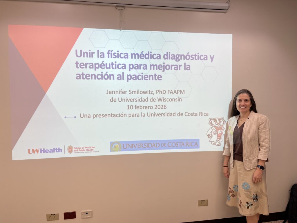 Woman stands in front of large screen presenting for a classroom
